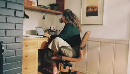 Osoba pracující na notebooku v domácí kanceláři při práci s AI